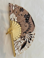 Decorative hand fan with intricate patterns on a light background