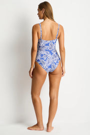 Woman wearing a blue floral swimsuit on a white background SEA LEVEL Palmera Cross front Multifit One Piece in Blue Iridescent Sea Fremantle perth
