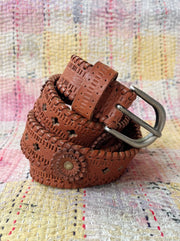 Brown woven belt with a silver buckle on a multicolored textured fabric background MAISON HOTEL Devendra Belt -  James Brown Iridescent Sea Fremantle Perth