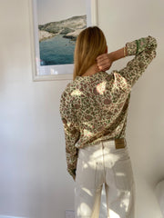 Floral print silk blouse in green and pink on a cream background